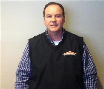 White male with plaid shirt and black SERVPRO vest