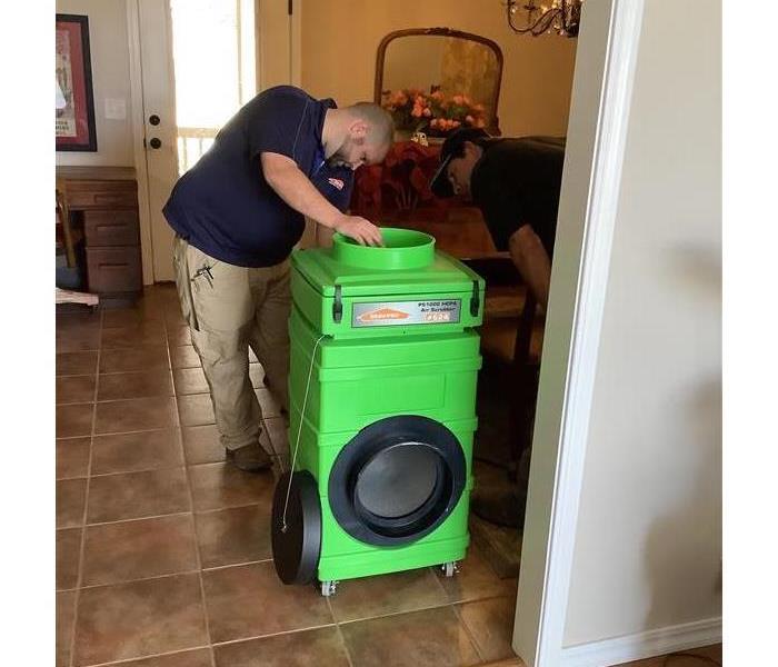 eric and mike putting the air scrubber together in a home