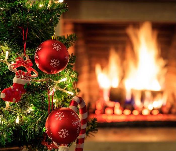 fire place blurred in background with christmas tree and christmas decorations in corner 