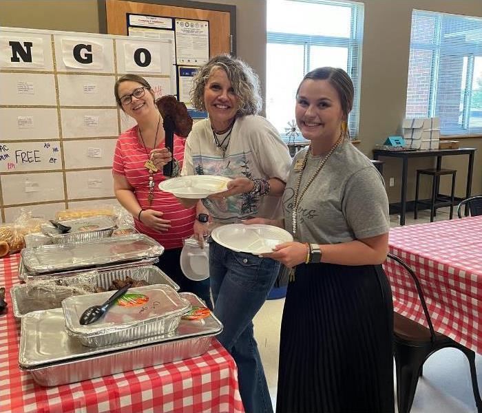three women smiling with food in support of teachers appreciation week